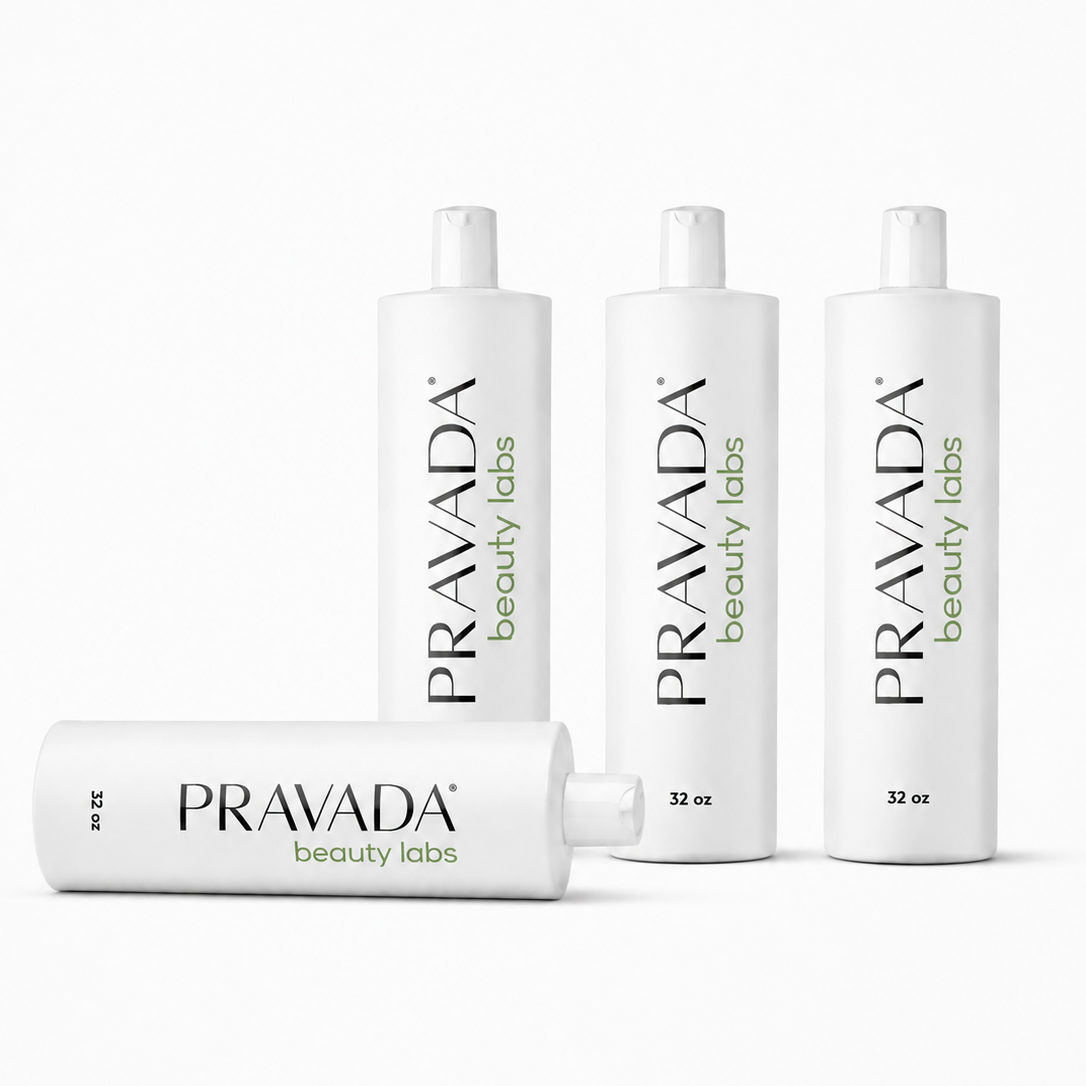 Four white cylindrical bottles of Pravada Beauty Labs products arranged on a clean white background, with three standing upright and one lying on its side.